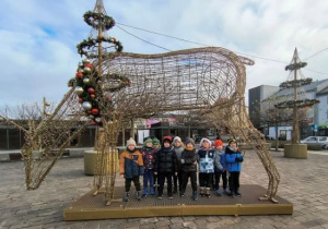 Chłopcy stoją pod dekoracją renifera na Placu Kościuszki.