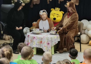 Trzy misie siedzą przy stoliku.