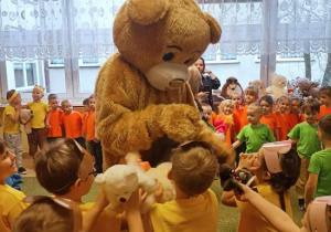 Teddy Eddie przytula dzieci.