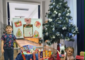 Klara i Kuba pokazują zgromadzone dary dla seniorów.