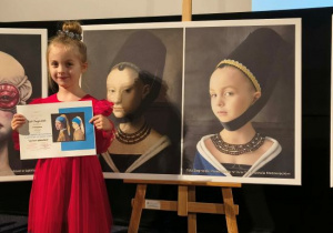 Tola stoi obok swojego obrazu.