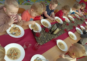 Przedszkolaki jedzą pyszną zupę pieczarkową.