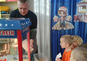 Kacper czeka na swoją porcję popcornu.