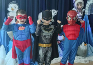 Chłopcy stoją w przebraniach superbohaterów.