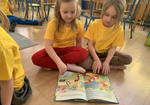 Blanka i Nikola oglądają książkę o Kubusiu Puchatku.