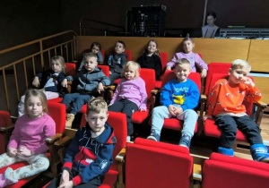 Dzieci siedzą na widowni i oczekują na bajkę.