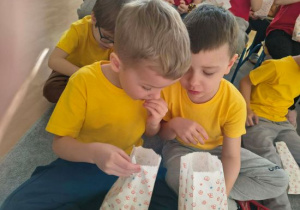 Igor i Olek jedzą smaczny popcorn.