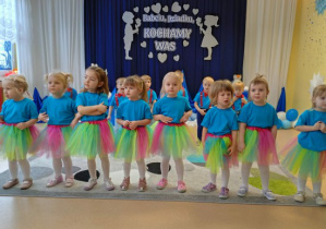 Dzieci stoją w dwuszeregu i śpiewają piosenkę