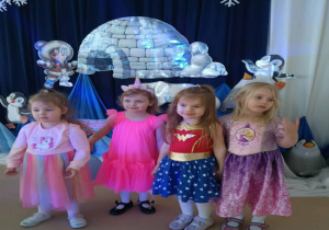 Cztery dziewczynki w kolorowych przebraniach pozują do zdjęcia