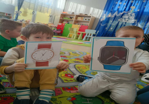 Chłopcy trzymają zdjęcia przedstawiające różne rodzaje zegarków na rękę