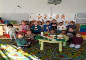 Grupa dzieci pozuje do zdjęcia na tle napisu dzień naleśnika