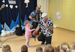 Dziewczynka kręci rączką młynka do kawy.