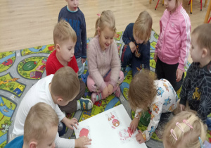 Dzieci układają walentynkowe puzzle.