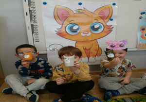 Chłopcy pokazują własnoręcznie wykonane koty z rolek po papierze toaletowym.