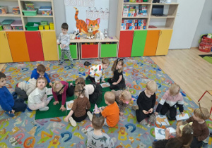 Dzieci układają puzzle z obrazków przedstawiających koty.