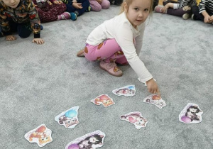 Dziewczynka pokazuje kota z kłębkiem włóczki.