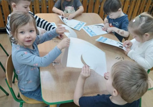 Dzieci tworzą pracę plastyczna z kotem.