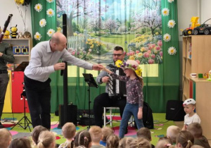 Ida w wiosennym kapeluszu występuje przed dziećmi.