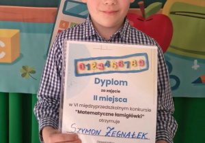 Szymon prezentuje swój dyplom.