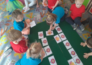 Dzieci dopasowują figury na skrzydłach motyli do figur na płatkach kwiatów.