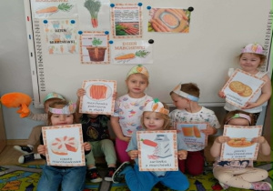 Dzieci trzymają ilustracje przedstawiające potrawy z marchewki.