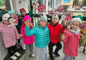 Dzieci stoją z emblematami wiosennymi.