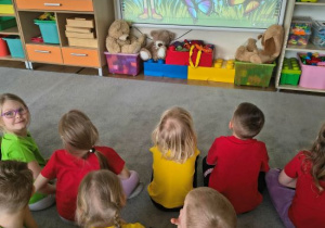 Dzieci oglądają film edukacyjny o motylach.