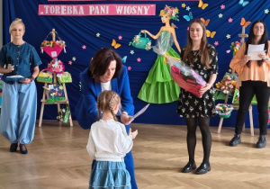 Tola odbiera dyplom i nagrodę.
