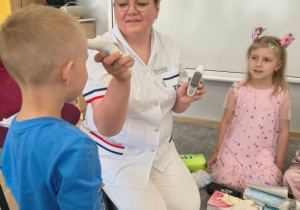Pani pielęgniarka mierzy dzieciom temperaturę.