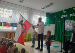 Pan Maciej pokazuje flagę Polski.