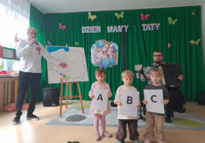 Dzieci pokazują litery alfabetu.
