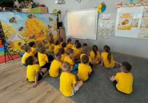 Dzieci oglądają film edukacyjny o pszczołach.