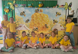Zdjęcie grupowe dziewczynek na tle pszczół.