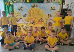 Zdjęcie grupowe chłopców na tle pszczół.