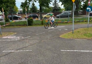 Leon jedzie rowerem po miasteczku rowerowym.