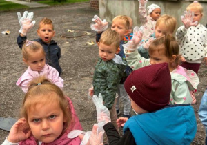 Dzieci pokazują rękawiczki, w których będą sprzątać najbliższą okolicę przedszkola.