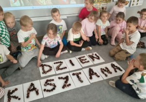 Dzieci ułożyły napis z kasztanów.