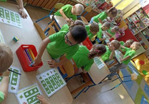 Dzieci wykonują kartę pracy z liśćmi.