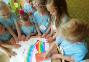 Grupa dzieci maluje tęczę