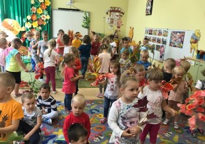 Wszystkie dzieci podczas wspólnego tańca z jesiennymi listkami.