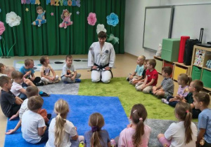 Trener opowiada dzieciom o taekwon-do.